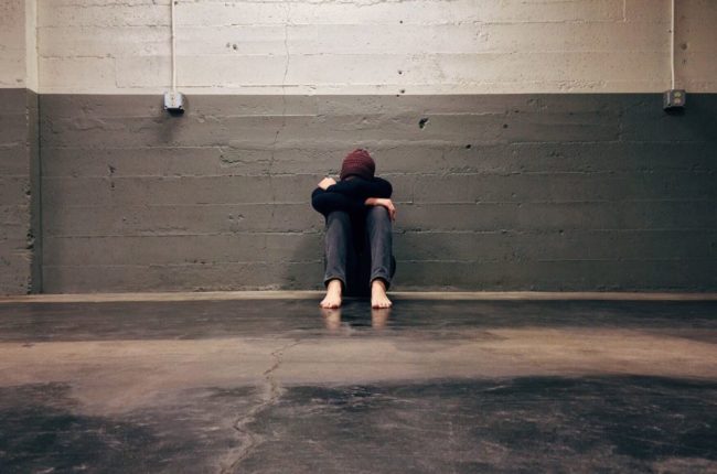 depressed man sits on floor